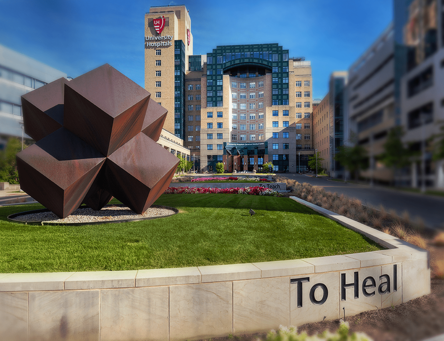 The University Hospitals Medical Center Building in the background and a large modern metal art piece in the foreground.