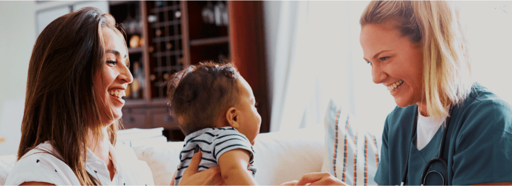 3a2e36ec4739deecea336c43d57800666afb4423 A smiling healthcare professional engaging with a mother and her baby in a home setting.