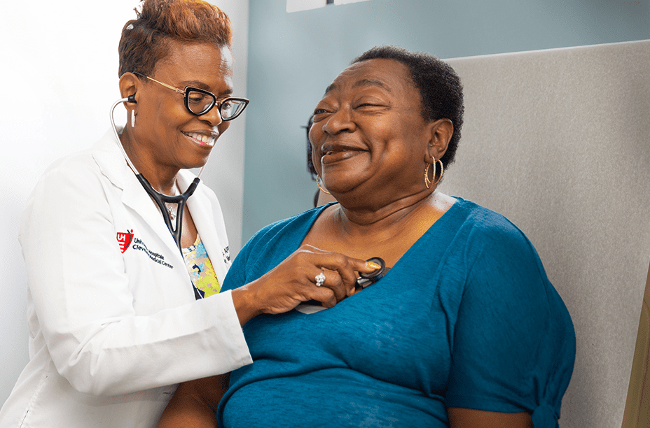 661e42478d01686f4e73b42111b41668ded10109 A smiling healthcare professional in a white coat uses a stethoscope to check a happy patient in a clinical setting.