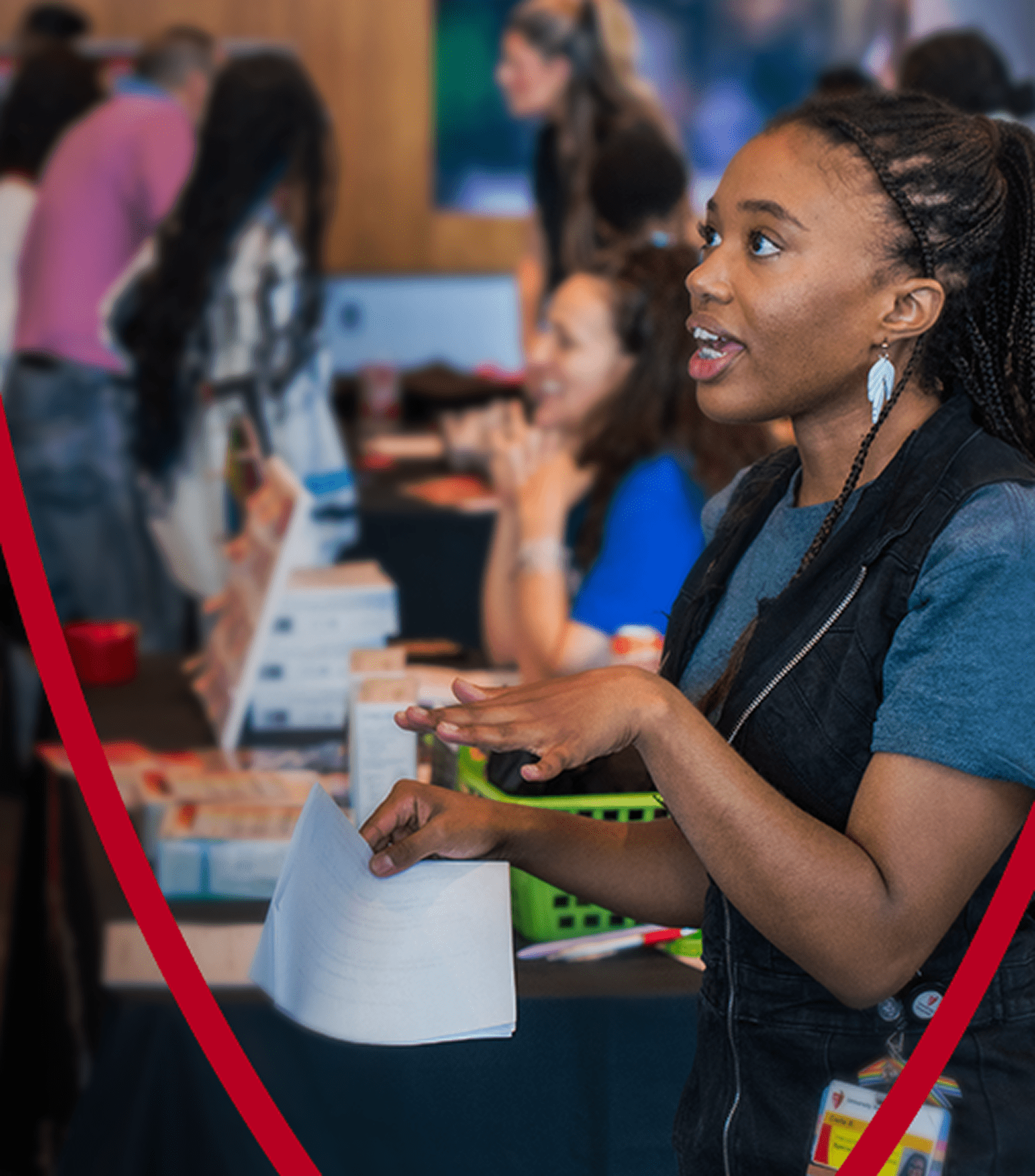 A healthcare professional enthusiastically speaks with attendees at a recruitment event.